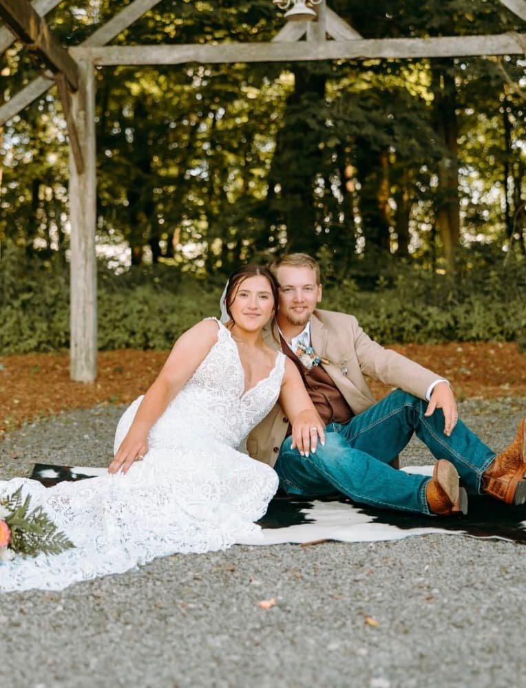 The couple sitting together on the farm.