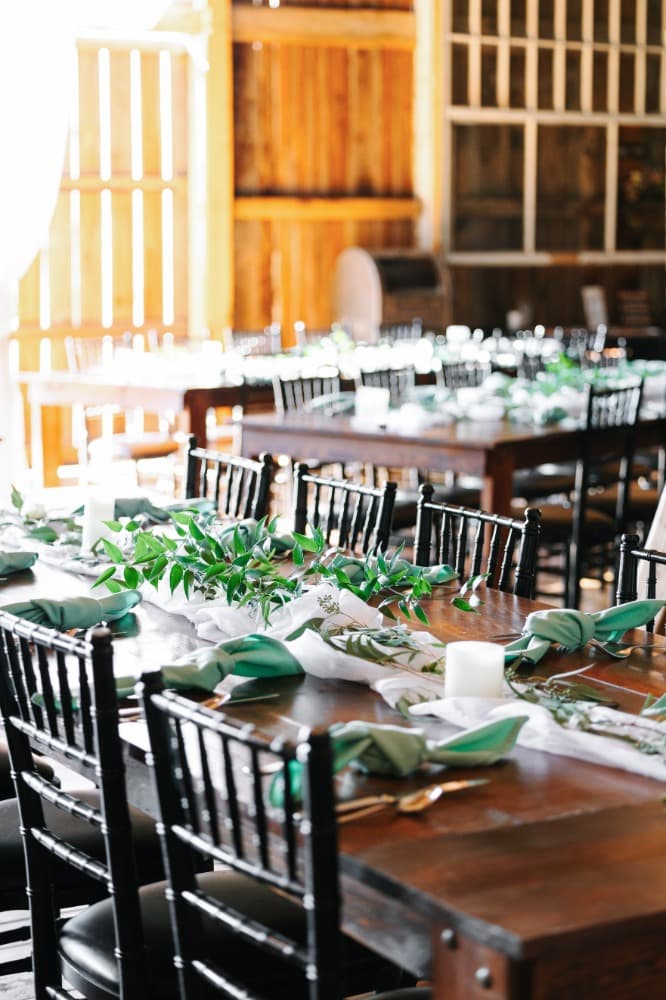 Close view of a place setting with a folded napkin, glassware and candlelight.